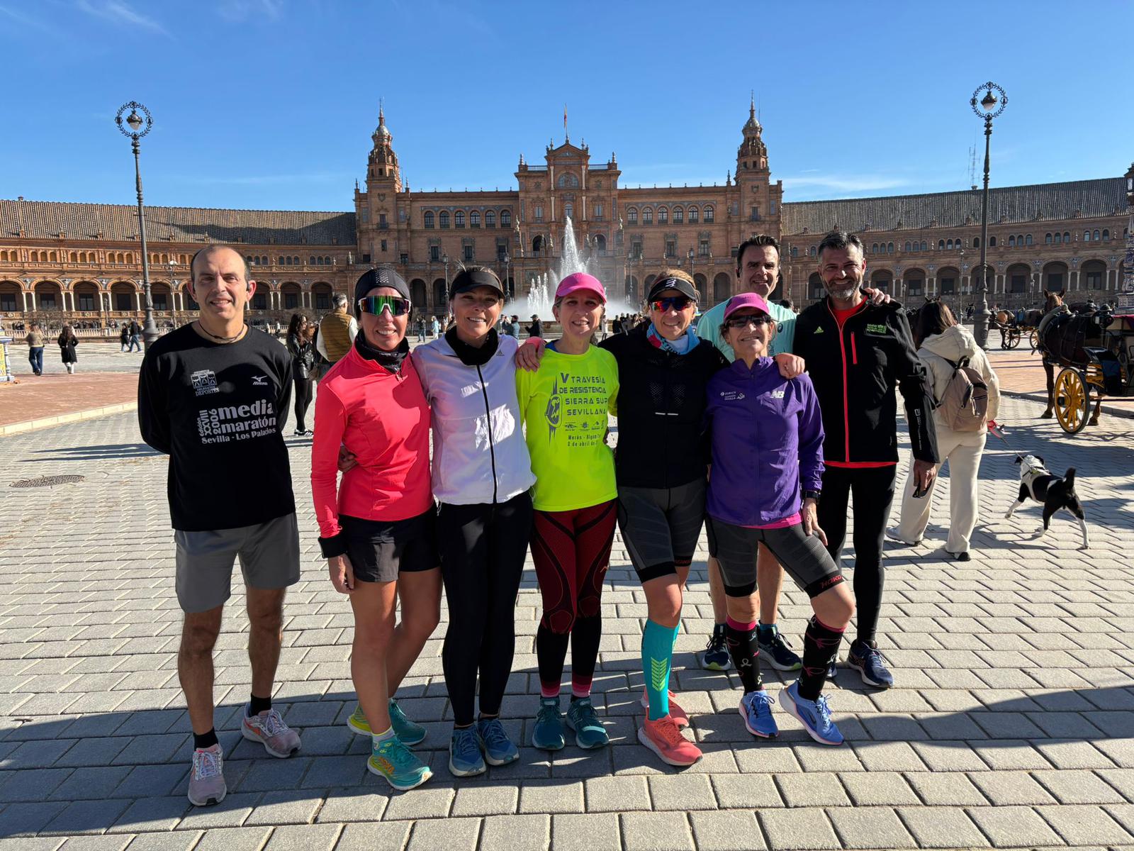 Group of runners posing in Seville's Plaza de España after a training session